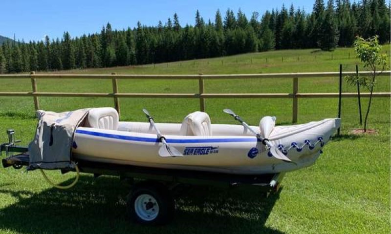 White inflatable kayak for sea and ocean is standing on the meadow
